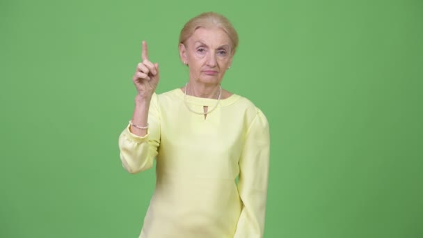 Vackra senior affärskvinna pekar uppåt — Stockvideo