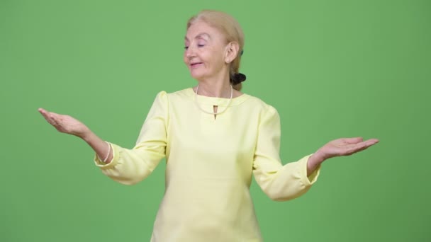 Bir şey karşılaştırma mutlu üst düzey iş kadını — Stok video