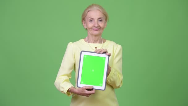 Güzel mutlu üst düzey iş kadını gösteren dijital tablet — Stok video