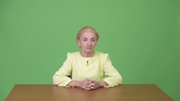 Belle femme d'affaires âgée heureuse souriant contre une table en bois — Video