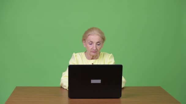 Schöne glückliche Seniorin mit Laptop und guten Nachrichten — Stockvideo