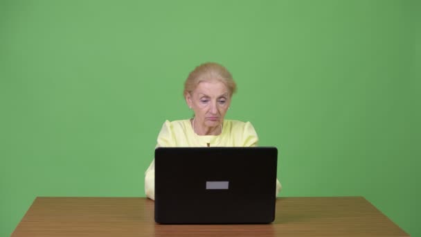 Seniorin benutzt Laptop und wirkt schockiert — Stockvideo