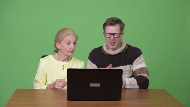 Senior-Geschäftsfrau und junger schöner Mann benutzen Laptop und bekommen schlechte Nachrichten zusammen — Stockvideo