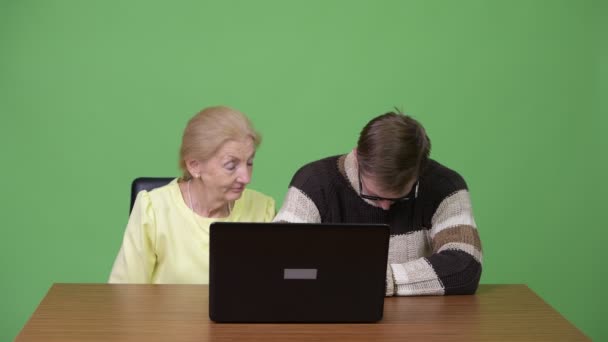 Senior businesswoman and young man using laptop while looking sleepy together — Stock Video