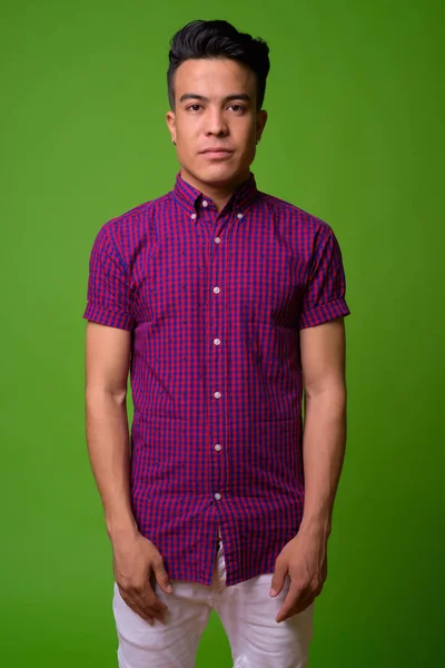 Молодой многонациональный мужчина в фиолетовой рубашке на зеленом фоне — стоковое фото