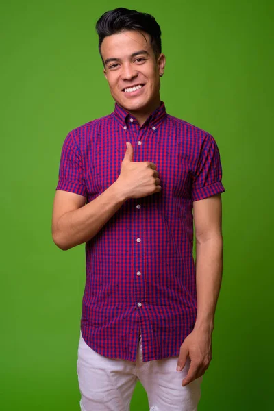 Jovem multi-étnico vestindo camisa roxa contra fundo verde — Fotografia de Stock