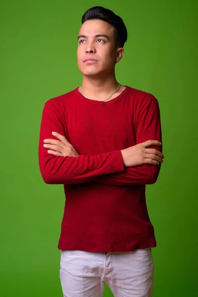 Több-etnikumú fiatalember visel zöld háttér piros pulóver — Stock Fotó