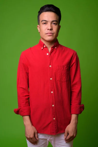 Jeune homme d'affaires multi-ethnique portant une chemise rouge sur fond vert — Photo