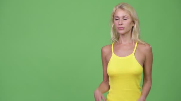 Jonge gelukkig mooie blonde vrouw die iets tonen — Stockvideo