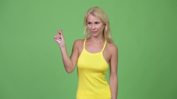 Fiatal boldog szép szőke nő harapós ujjait, és bemutatja, hogy valami — Stock videók
