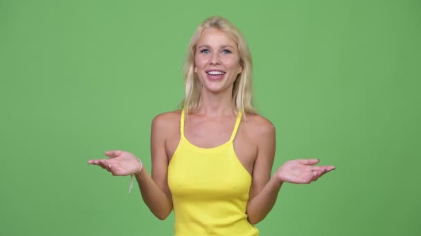 Jovem mulher loira bonita feliz apresentando algo — Vídeo de Stock