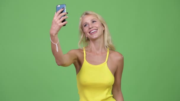 Jovem mulher loira bonita feliz tomando selfie — Vídeo de Stock