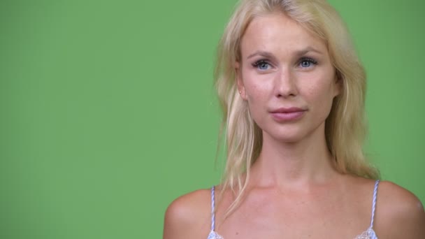 Jonge gelukkig mooi zakenvrouw denken tegen groene achtergrond — Stockvideo