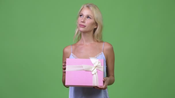 Jeune heureuse belle femme d'affaires pensant tout en tenant boîte cadeau — Video