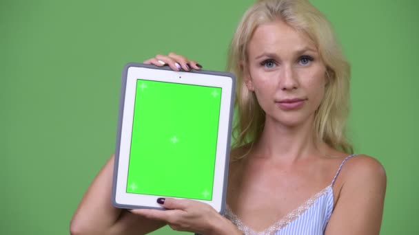 Junge glückliche schöne Geschäftsfrau zeigt digitales Tablet — Stockvideo