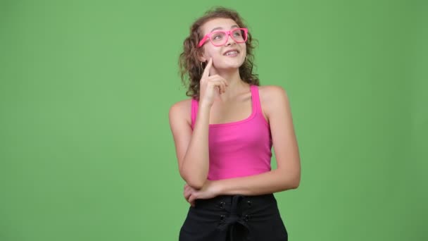 Junge glückliche schöne Nerd-Frau denkt, während sie nach oben schaut — Stockvideo