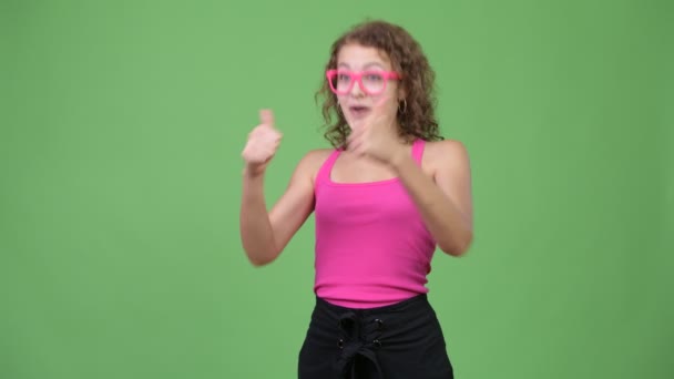 Jovem feliz linda nerd mulher dando polegares para cima e olhando animado — Vídeo de Stock