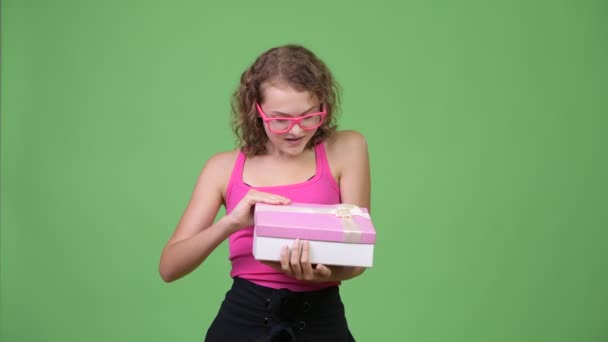 若い幸せな美しいオタク女性ギフト ボックスを開くと、見てみるとビックリ — ストック動画