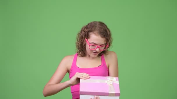 Молода щаслива красива жінка-нод відкриває подарункову коробку і виглядає здивованою — стокове відео