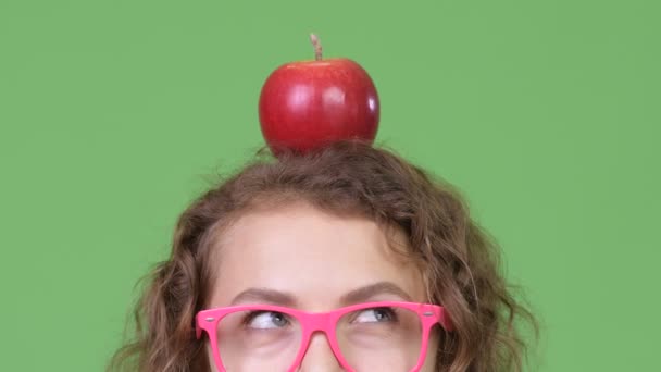 年轻书妇女在她的头上用红色苹果思考 — 图库视频影像