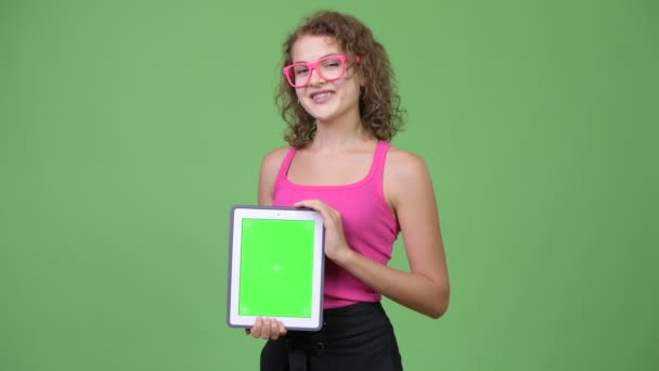 Junge glückliche schöne Nerd-Frau zeigt digitales Tablet — Stockvideo