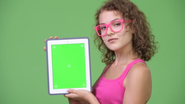 Joven feliz hermosa mujer nerd mostrando tableta digital — Vídeos de Stock