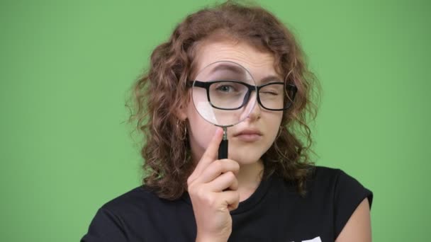 Νέοι όμορφη nerd γυναίκα χρησιμοποιώντας μεγεθυντικό φακό — Αρχείο Βίντεο