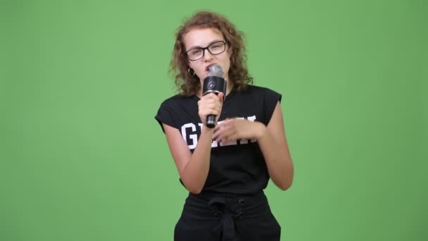 Jovem feliz linda nerd mulher apresentando algo com microfone — Vídeo de Stock