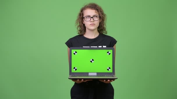 Jovem bela nerd mulher pensando ao mostrar laptop — Vídeo de Stock