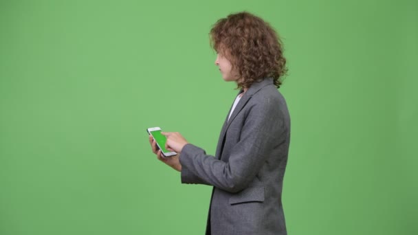 Giovane bella donna d'affari con i capelli biondi ricci utilizzando il telefono — Video Stock