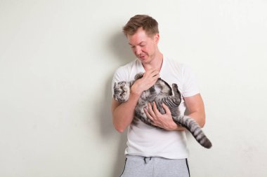 Tutarak şirin kedi gülümseyen mutlu yakışıklı delikanlı