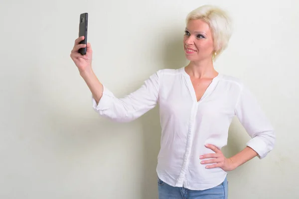Glückliche blonde Geschäftsfrau mit kurzen Haaren macht Selfie — Stockfoto