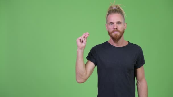 Счастливый красивый бородатый мужчина щёлкает пальцами и показывает что-то — стоковое видео