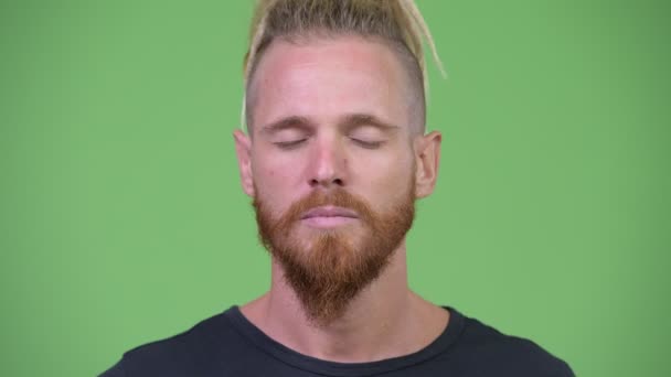 Homem barbudo bonito feliz com dreadlocks fechando os olhos enquanto relaxa — Vídeo de Stock