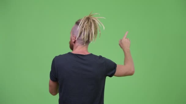 Baksidan på skäggig man med dreadlocks pekar finger — Stockvideo