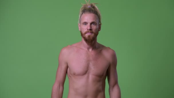 Handsome muscular bearded man with dreadlocks crossing arms shirtless — Stock Video