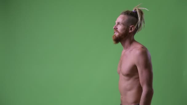 Profilo vista di bel muscoloso uomo barbuto con dreadlocks sorridente senza maglietta — Video Stock