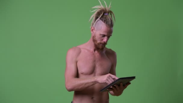 schöner muskulöser bärtiger Mann mit Dreadlocks mit digitalem Tablet-Hemd