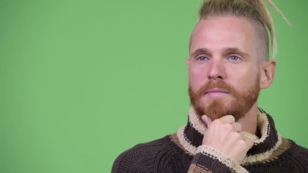 Ευτυχισμένος όμορφος γενειοφόρος άνδρας με dreadlocks σκέψης ενώ φοράει ζεστά ρούχα — Αρχείο Βίντεο