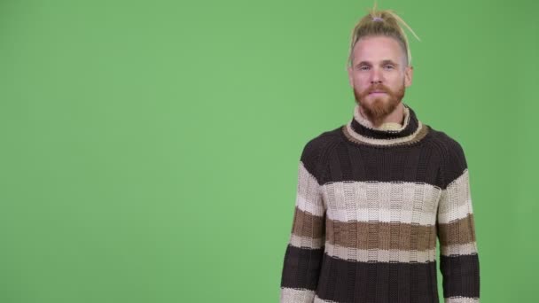 Feliz hombre barbudo guapo con rastas mostrando algo — Vídeos de Stock