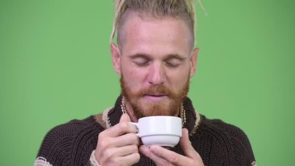 Glücklicher gutaussehender bärtiger Mann in warmer Kleidung, während er Kaffee mit geschlossenen Augen riecht — Stockvideo