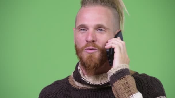 Ευτυχισμένος όμορφος γενειοφόρος άνδρας μιλάει στο τηλέφωνο ενώ φορώντας πουλόβερ — Αρχείο Βίντεο