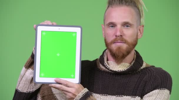 Heureux beau barbu homme souriant tout en montrant tablette numérique — Video