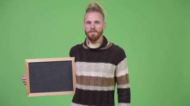 Gelukkig knap bebaarde man tonen blackboard en geven duimen omhoog — Stockvideo