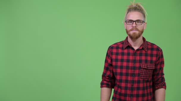 Homem hipster barbudo bonito feliz com dreadlocks mostrando algo — Vídeo de Stock