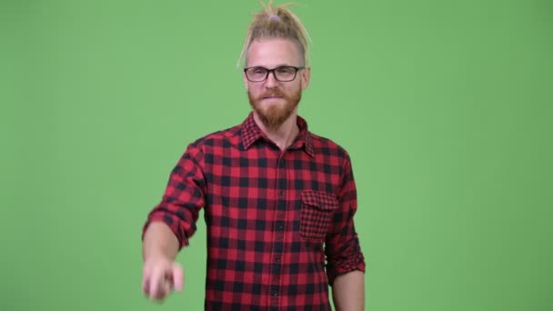 Joyeux beau barbu hipster homme avec dreadlocks pointant doigt — Video