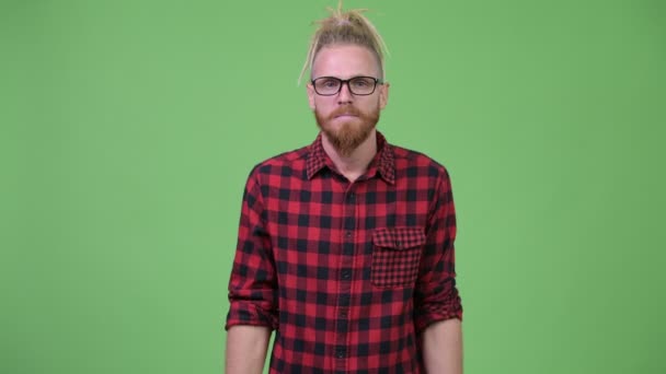 Handsome bearded hipster man with dreadlocks shrugging shoulders — Stock Video