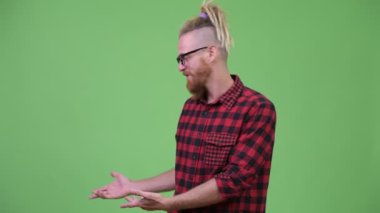 Yakışıklı sakallı hippi adam bir şey sunmak dreadlocks ile