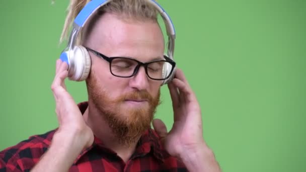 Stilig skäggiga hipster man med dreadlocks lyssnar på musik — Stockvideo