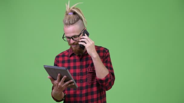 Happy vousatý muž bokovky s dredy mluvil po telefonu při používání digitálních tablet — Stock video